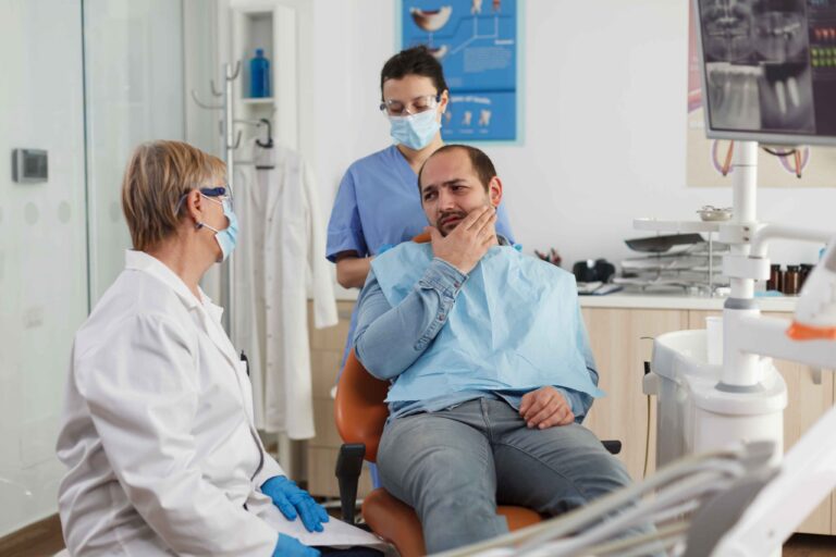 Patient discussing tooth pain with a dentist.