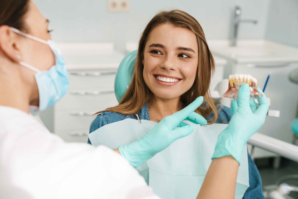 Dentist explaining a dental implant model to a patient.