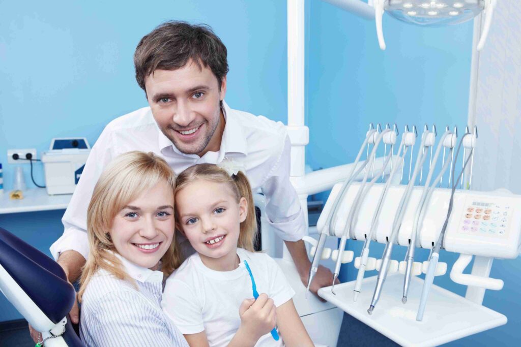 Smiling family with child in a dental office.
